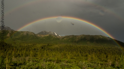 A rainbow arches over the mountains along the Richardson Highway. 